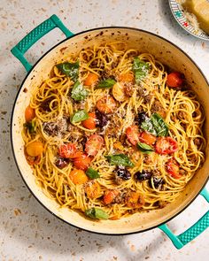 a pan filled with pasta and vegetables on top of a table