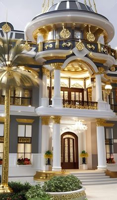 a large white and gold building with lots of windows on the top floor, surrounded by palm trees