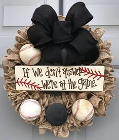 a wreath with baseballs and a sign that says if we don't answer, we're at the game