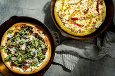 two pizzas sitting in pans next to each other on top of a table