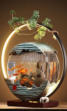 a fish bowl with goldfish in it on top of a wooden table next to a plant