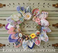 a wreath made out of fabric and flowers on a white door frame with the words lora bloom guest written below it