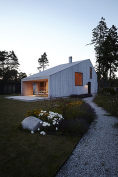 the house is surrounded by grass and flowers