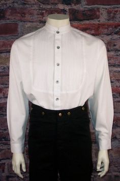 Men's Old West Vicorian Shirt This is one of our most authentic Victorian-era men’s shirts. This men’s shirt features a pleated inset bib and had a full button placket. The shirt sports a tailed banded collar of the Victorian/Edwardian era. Pewter buttons complete the authentic detail to this vintage style men’s shirt.The shirt is 100% cotton. Please machine wash in cold and tumble dry on low. Classic Cotton Shirt With Stand Collar, Classic Stand Collar Shirt For Fall, Classic Fall Shirt With Stand Collar, Classic Cotton Top With Stand Collar, Classic Shirt With Stand Collar And Placket, Traditional Fitted Shirt With Buttons, Classic Formal Tops With Stand Collar, Classic Semi-formal Top With Stand Collar, Fitted Classic Pleated Tops