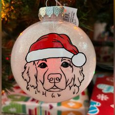 a glass ornament with a dog wearing a santa hat