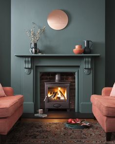 a living room with two chairs and a fire place in the middle of the room