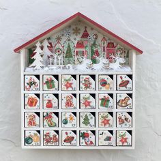 a white and red house with christmas decorations on the front, surrounded by snowflakes