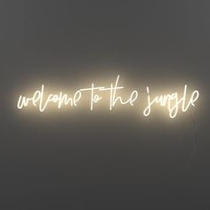 a neon sign with the words welcome to the jungle written in white on a dark background