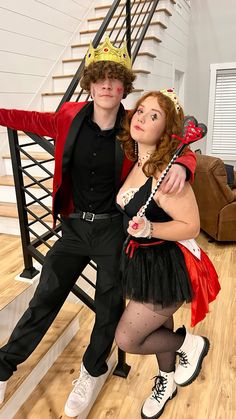 a man and woman dressed up in costumes posing for a photo on the stairs with their arms around each other