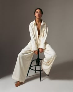 a woman sitting on top of a stool