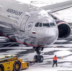 an airplane is parked on the tarmac with its wheels down and people walking around it