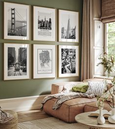 a living room with green walls and pictures on the wall above the couch, along with vases filled with flowers