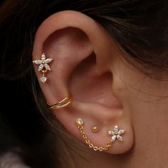 a close up of a person's ear with three different piercings on it