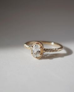 a gold ring with an oval shaped diamond in the center and two rows of diamonds around it