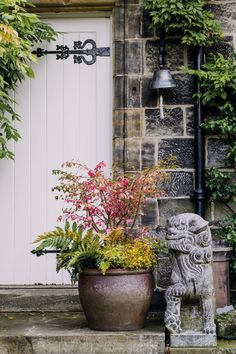 a stone statue sitting next to a potted plant