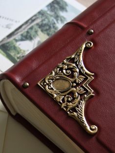 a red book with an ornate design on the front and back cover is sitting on a table