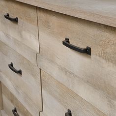 a wooden dresser with black handles and drawers