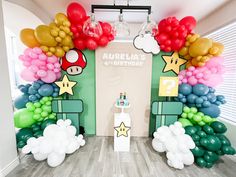 a room decorated with balloons and mario birthday decorations