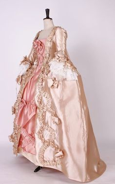 Evoke the splendor of an age of extravagance with our Blush Pink Rococo Fantasy Gown. The lustrous champagne gold of the gown is expertly complemented by soft blush pink tones, embodying the lavishness of baroque court attire. Exquisite ruffles and ornate detailing cascade down the bodice and skirt, as if conjured from the opulent palaces of rococo France. Lace cuffs and pearl embellishments whisper tales of Marie Antoinette’s luxurious soirees, while the structured silhouette honours the grande Pink Rococo, Rococo Gown, Marie Antoinette Style, Georgian Dress, Marie Antoinette Dresses, Rococo Dress, Antoinette Dress, 18th Century Dress, Rococo Fashion