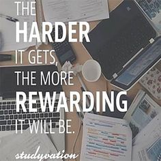 a desk with laptops, papers and other items on it that says, the harder it gets, the more rewarding it will be