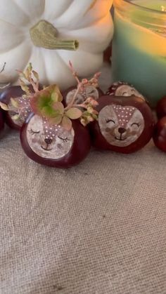 an assortment of decorative items on a table next to a candle and some pumpkins