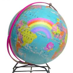 a small globe on a stand with a rainbow painted on the front and side of it