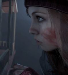 a girl with blood on her face looking out the window at something in the distance