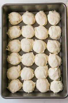 a baking pan filled with white frosting on top of a counter