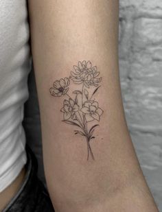 a small flower tattoo on the arm