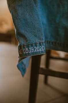 the back of a person's jean pants with an embroidered date label on them