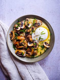 a bowl filled with food on top of a white cloth next to a fork and napkin