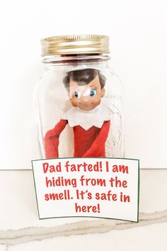 an elf in a glass jar with a sign on it