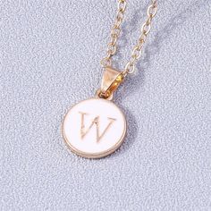 Add a personalized touch to your look with our YourLetter White Enamel Circle Necklace. Crafted with a white enamel background and gold color detailing, the necklace comes with a choice of single letter pendant. A great way to show off your initials or those of someone you love. Gold Initial Pendant Necklace With Letter Print, Minimalist White Jewelry With Initial Pendant, Personalized Gold Enamel Charm Necklace, Trendy White Pendant Charm Necklaces, Trendy White Pendant Charm Necklace, White Initial Pendant Necklace, White Initial Pendant Necklace With Monogram, White Monogram Initial Pendant Jewelry, White Minimalist Initial Pendant Necklace