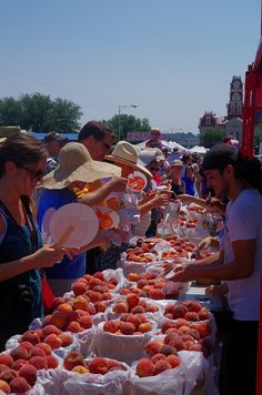 people are shopping at an outdoor market with lots of peaches on the tables and in bags