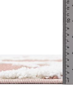 a white and pink rug with a measuring tape