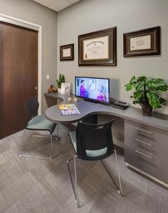 an office with a desk, chair, and computer monitor on the wall in front of it