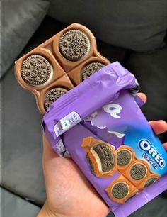 a person holding up a chocolate bar with oreo cookies on it