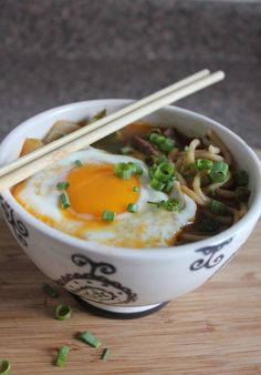 an egg and noodles dish in a bowl with chopsticks