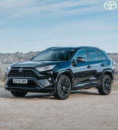 a black toyota rav parked in the dirt