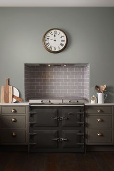 a kitchen with an oven, stove and clock on the wall