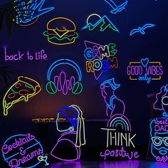 neon signs are lit up on the wall in front of a dark room with palm trees