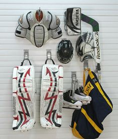 the hockey goalie's gear is hanging up on the wall next to their gloves