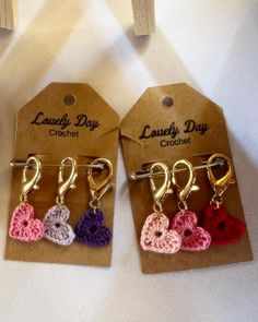 three small crocheted hearts hang from hooks on a carded gift bag for someone's special day