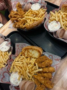 two trays filled with chicken sandwiches and french fries