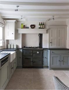 a kitchen with gray cabinets and white walls