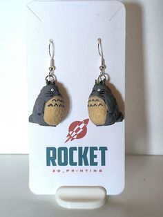 a pair of earrings with an image of a gorilla head and lightning bolt on it