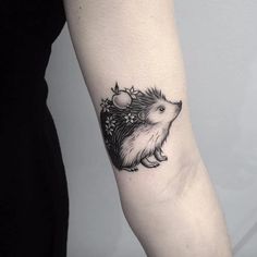 a small hedgehog tattoo on the arm