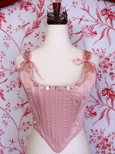 Be the star of the show with this gorgeous Renaissance to Baroque Era corset, this time in a special ballet pink satin! This piece features hand-sewn mauve and ivory rosette adornments, pink satin ribbon finishes, adjustable straps, and a classic Tudor Era design. Style it over a delicate dress or blouse with a puffy skirt for the perfect historically-inspired ballerina look. Sizing: ✧IN✧ Bust Waist S 30-34 Inches 24-28 Inches M 34-38 Inches 28-32 Inches L 38-42 Inches 30-34 Inches XL 40-44 Inches 36-40 Inches ✧CM✧ Bust Waist S 75-85 CM 60-70 CM M 85-95 CM 70-80 CM L 95-105 CM 75-85 CM XL 100-110 CM 90-100 CM Materials:10% Elastane 90% Polyester Care:Gently hand wash or dry clean only. Air dry only, hang or dry flat. Corset Stays, Baroque Era, Delicate Dress, Fantasy Shop, Tudor Era, Puffy Skirt, Ballet Pink, Medieval Fashion, Rococo Style