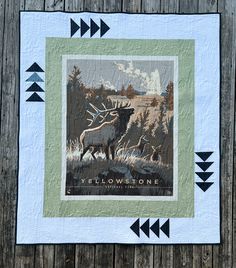 a quilt with an image of a moose and two arrows on the side of it