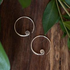 A lovely little set of pure silver hoop earrings enclosing a small silver spiral. Spirals represent growth and movement through life's experiences. Each pair from Gadabout Goods was hand carved by silversmiths from the Karen Hill Tribe in northern Thailand. Measures approximately 1" tall x 75" wide Especially prized for its shine and craftsmanship, Karen Hill Tribe jewelry is made using only 98% silver or higher. Compared to the 92.5% silver of sterling, this higher grade silver has a beautiful Tribe Jewelry, Northern Thailand, Sterling Jewelry, Small World, Silver Hoops, Silver Hoop Earrings, Pure Silver, Hand Carved, Hoop Earrings